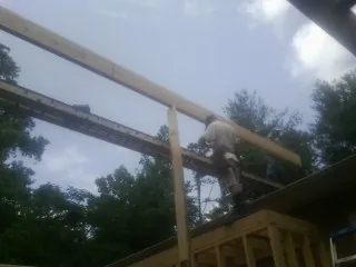 Carpenter setting a ridge beam over a new addition frame — Ice Dam Removal by Roofing Brothers in Vergas
