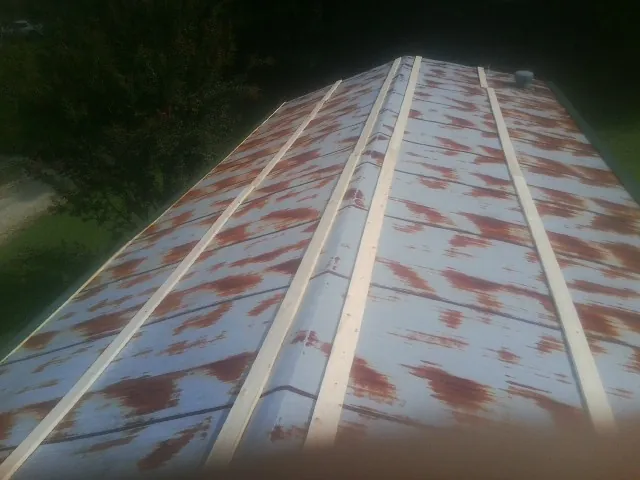 Rusted metal roof panels with new wood purlins before replacement — Storm Damage Roof Repair in Vergas by Roofing Brothers