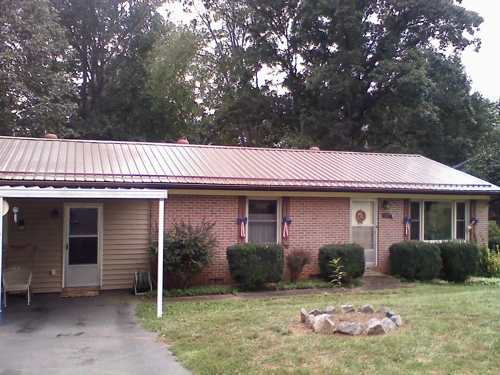 Bronze metal roof and carport on a brick ranch home — Roof Repair work by our crew in Vergas
